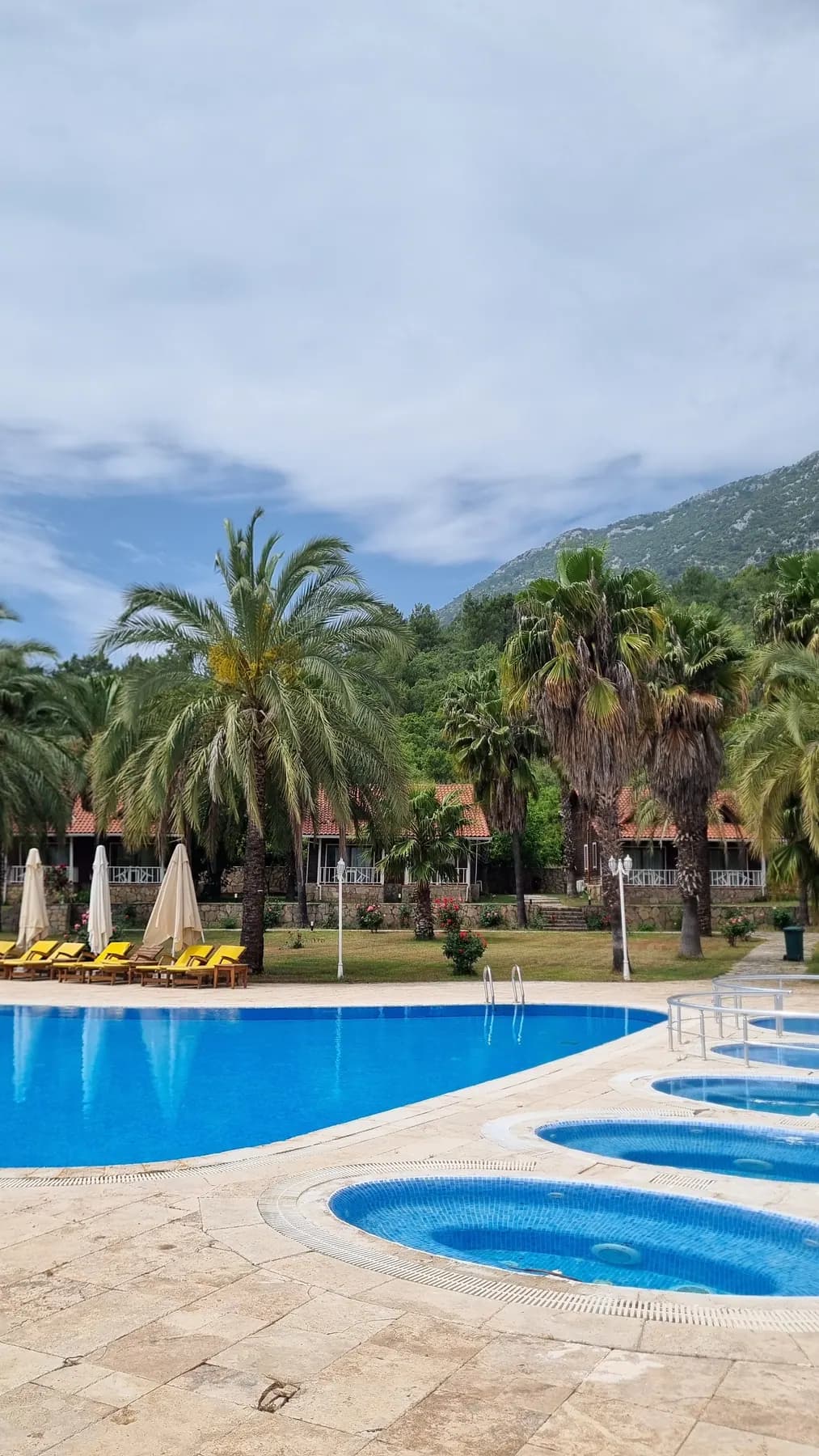 Club Sun Village açık yüzme havuzu, şezlonglar ve palmiyeler