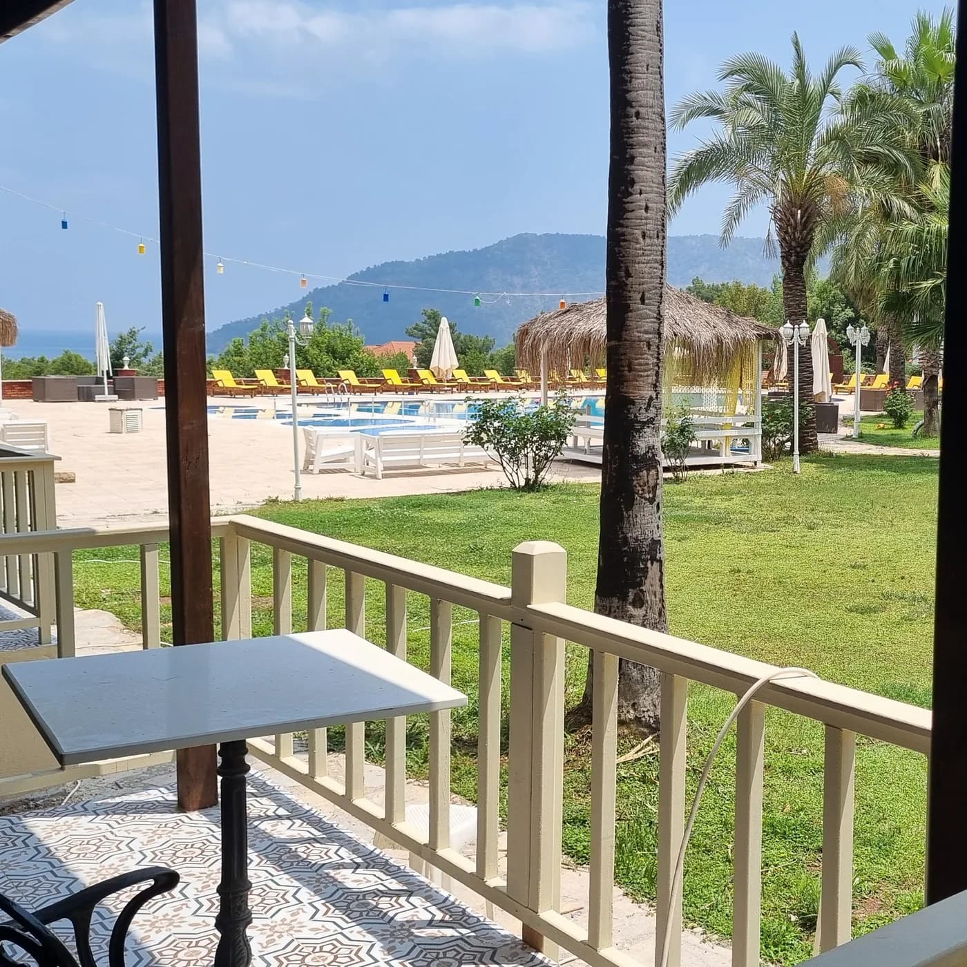 Club Sun Village bungalov balkonundan havuz, bahçe ve deniz manzarası