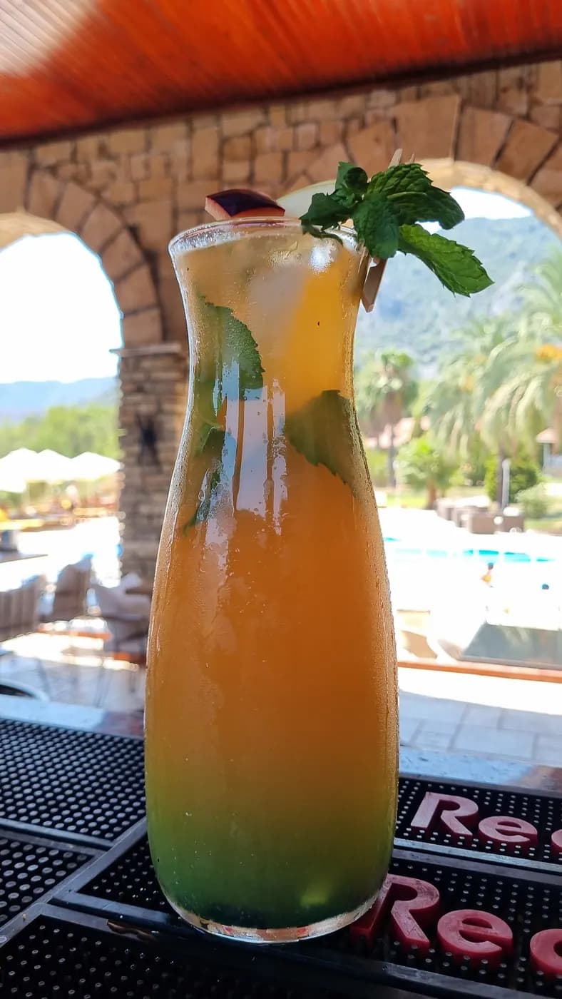 Club Sun Village bar, taş kemerler önünde kokteyl